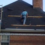 workers repairing house roofing