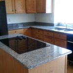 A kitchen featuring granite countertops and wood cabinets