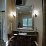 bathroom vanity mirror with a dark wooden countertop