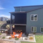 house with a patio and stairs to a spacious, green backyard
