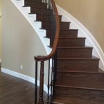 A curved wooden staircase with a dark wood finish