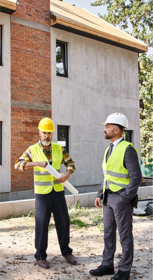 img - devoted-architect-builder-safety-vests-holding-blueprint-discussing-construction-process