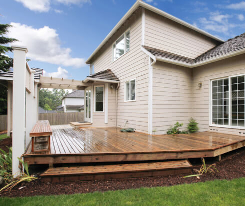 Large wooden custom deck designed for the back of a house