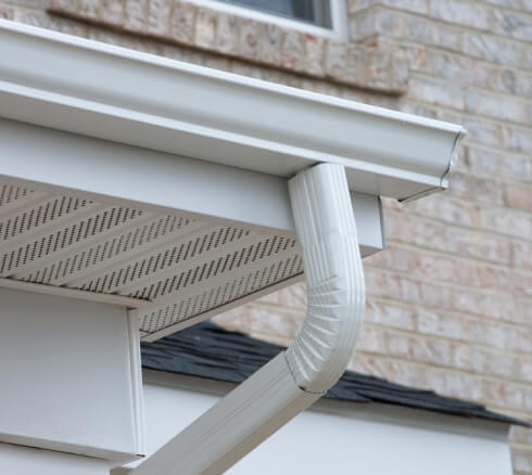 Newly installed rain gutter drain on a house