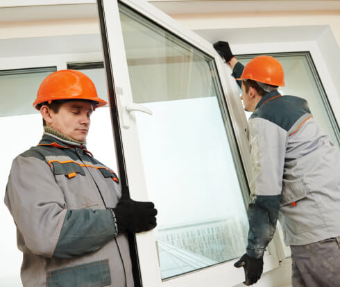 Two workers installing a replacement glass window	