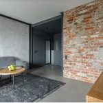 small living room with concrete wall and floor