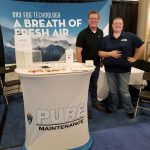Two Pure Maintenance staff standing in the company booth