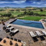 large swimming pool and patio area overlooking a golf course