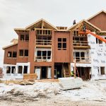 workers covering house exterior with house wrap