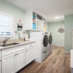 indoor laundry area with two washing machines beside the sink