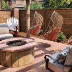 firepit surrounded by chairs and hanging wooden hammocks