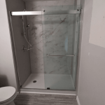 shower area with half-open glass sliding door